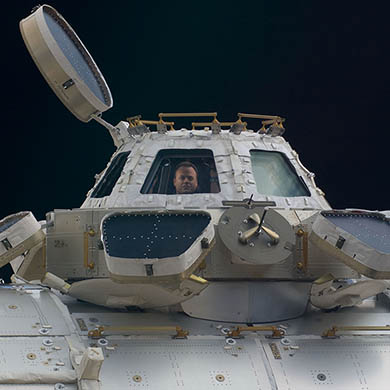 Ron Garan, Expedition 28 flight engineer, is pictured in a window of the Cupola of the International Space Station